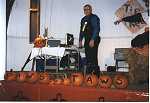 Stage display of pumpkins spelling out Paws and Taws with caller in background.