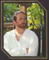 Phillip outside with porch background in white medieval shirt.