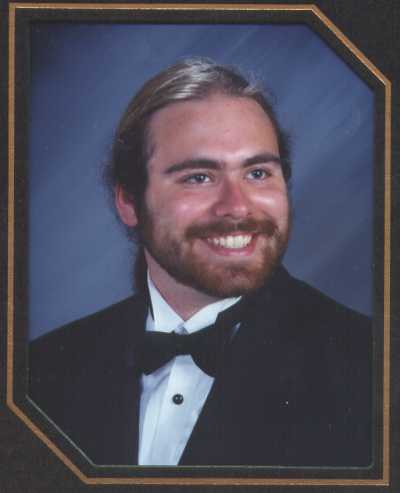 Phillip in tuxedo smiling looking to the left.